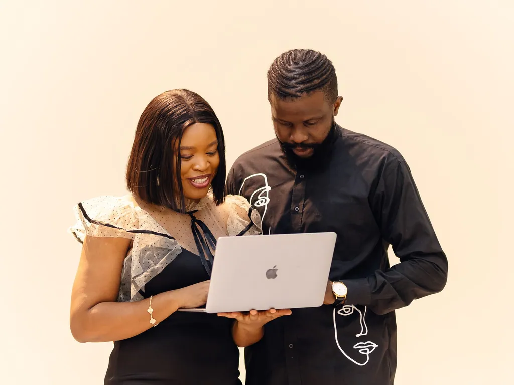 Two colleagues reviewing a project together on a laptop in a Lagos office